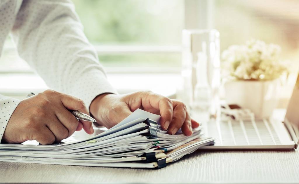 businessman-hands-holding-pen-for-working-in-stacks-of-paper-files-picture-id1024409632 businessman-hands-holding-pen-for-working-in-stacks-of-paper-files-picture-id1024409632