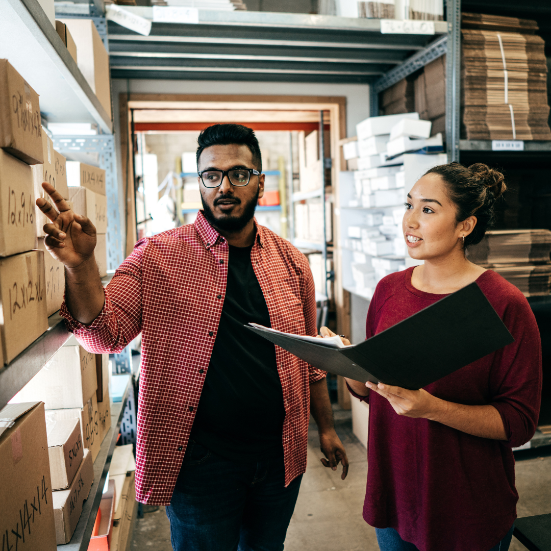 8 two people standing next to shelves of boxes