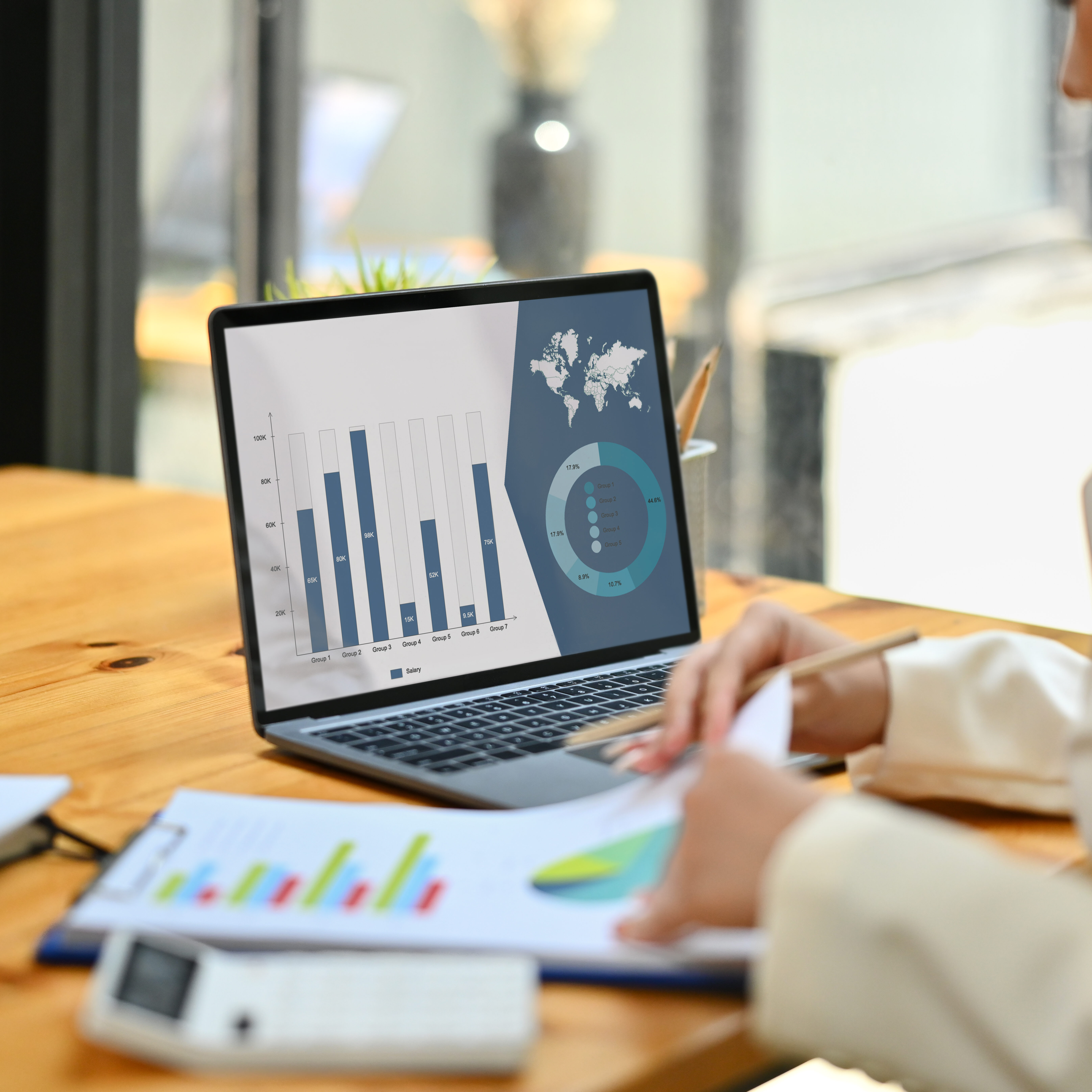 Side view of female worker analyzing financial data and planning marketing strategy at her workplace. Side view of female worker analyzing financial data and planning marketing strategy at her workplace.