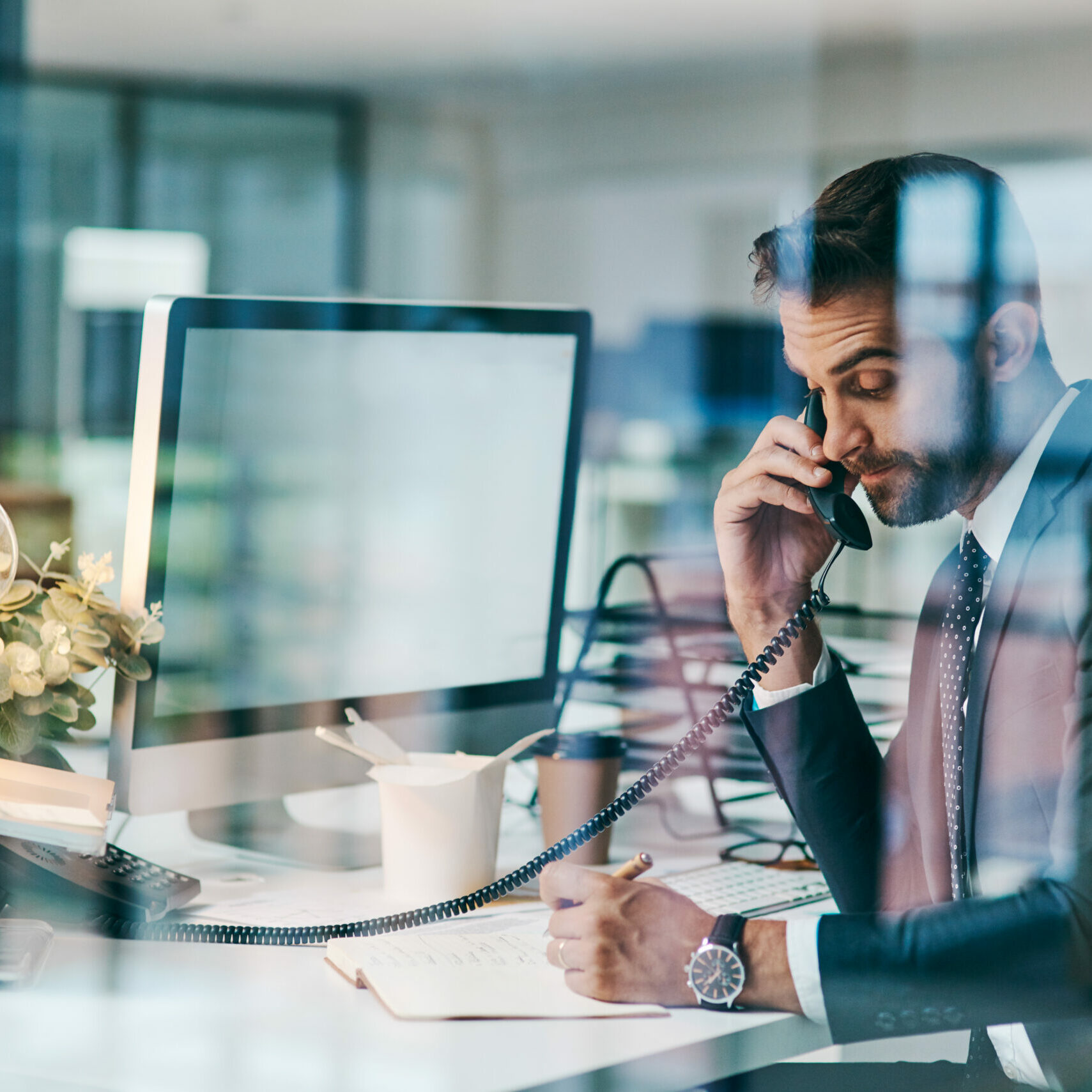 Busy with an important deal over the phone Shot of a focused young businessman making a call while being seated inside of the office
